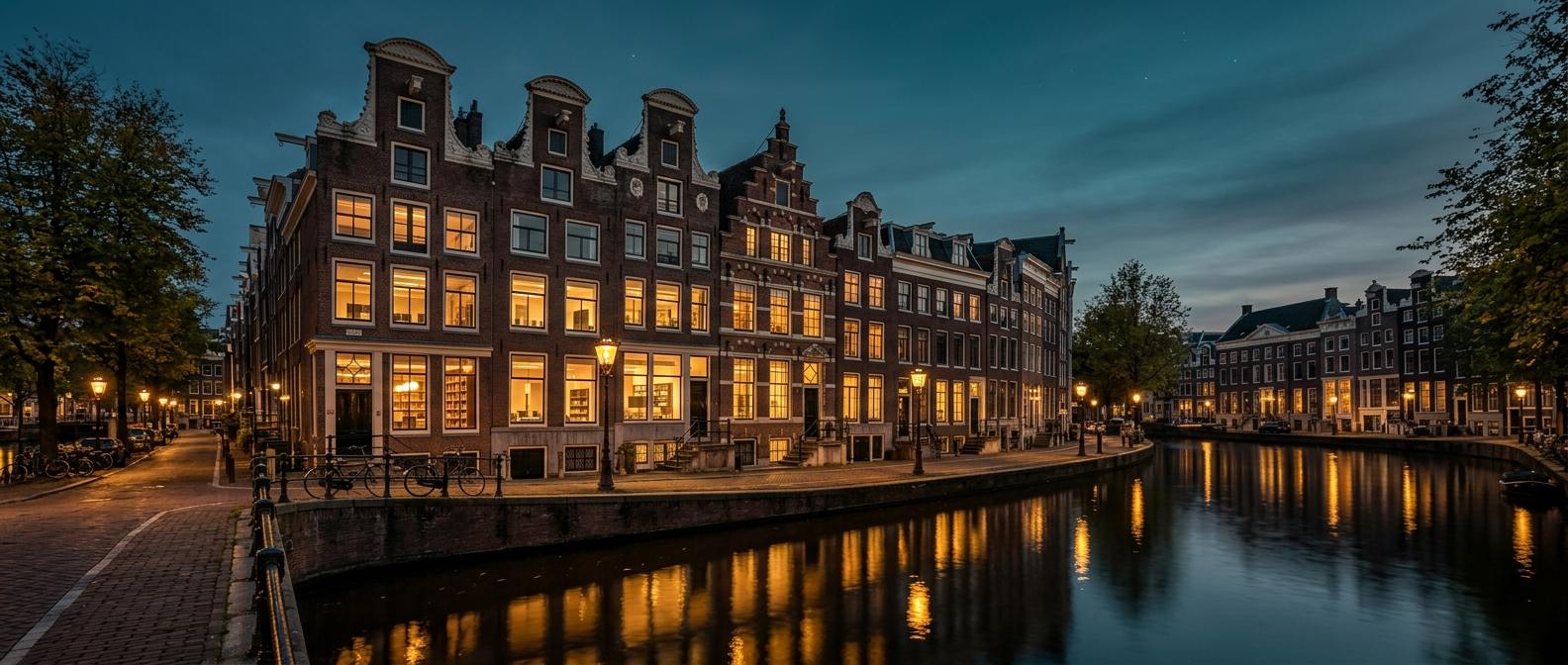 Restored canal-front buildings in Amsterdam at dusk