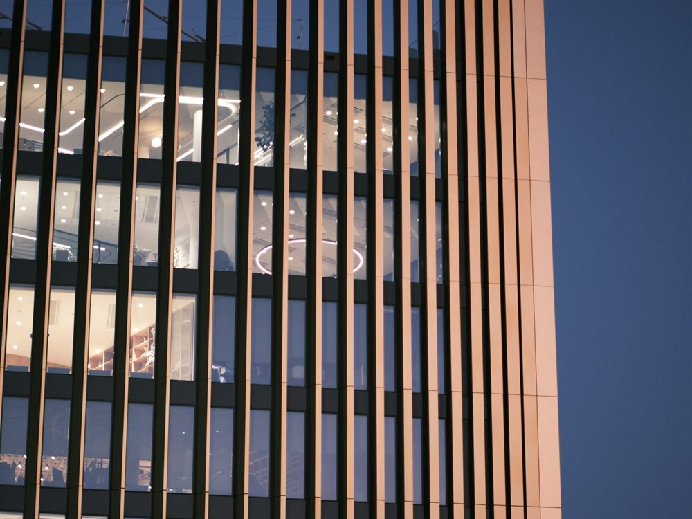 Modern building facade with warm interior lighting at dusk